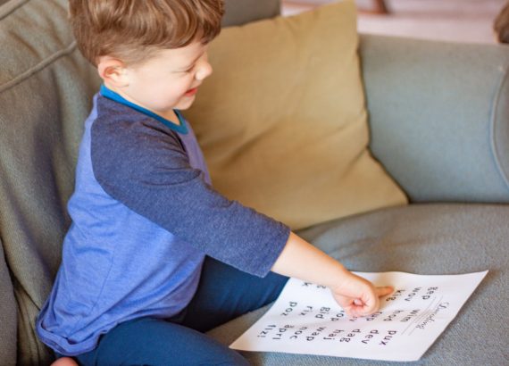Young boy reading from a nonsense word worksheet